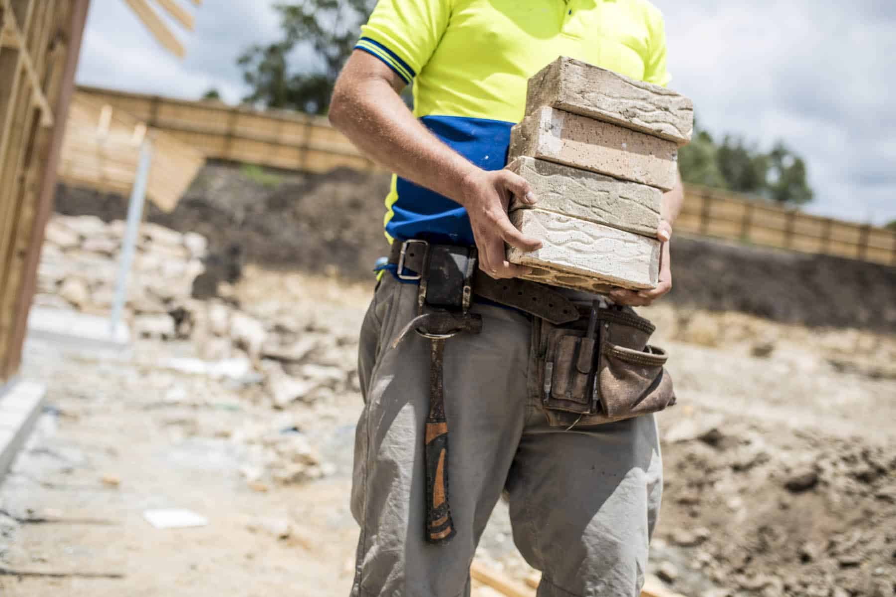 worker holding stack of bricks